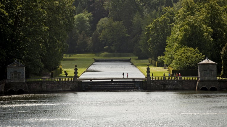 Visitors walking on the cascade between the canal and the lake at Studley Royal Water Garden, North Yorkshire.